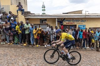 Residents gather to look at Israel Premier Techâ€™s British rider Joseph Blackmore, competing during the final stage of the 16h Tour du Rwanda on 25 February 2024, in Kigali. Blackmore, won the Tour of Rwanda which ended on Sunday in the capital Kigali. (Photo by Guillem Sartorio / AFP)