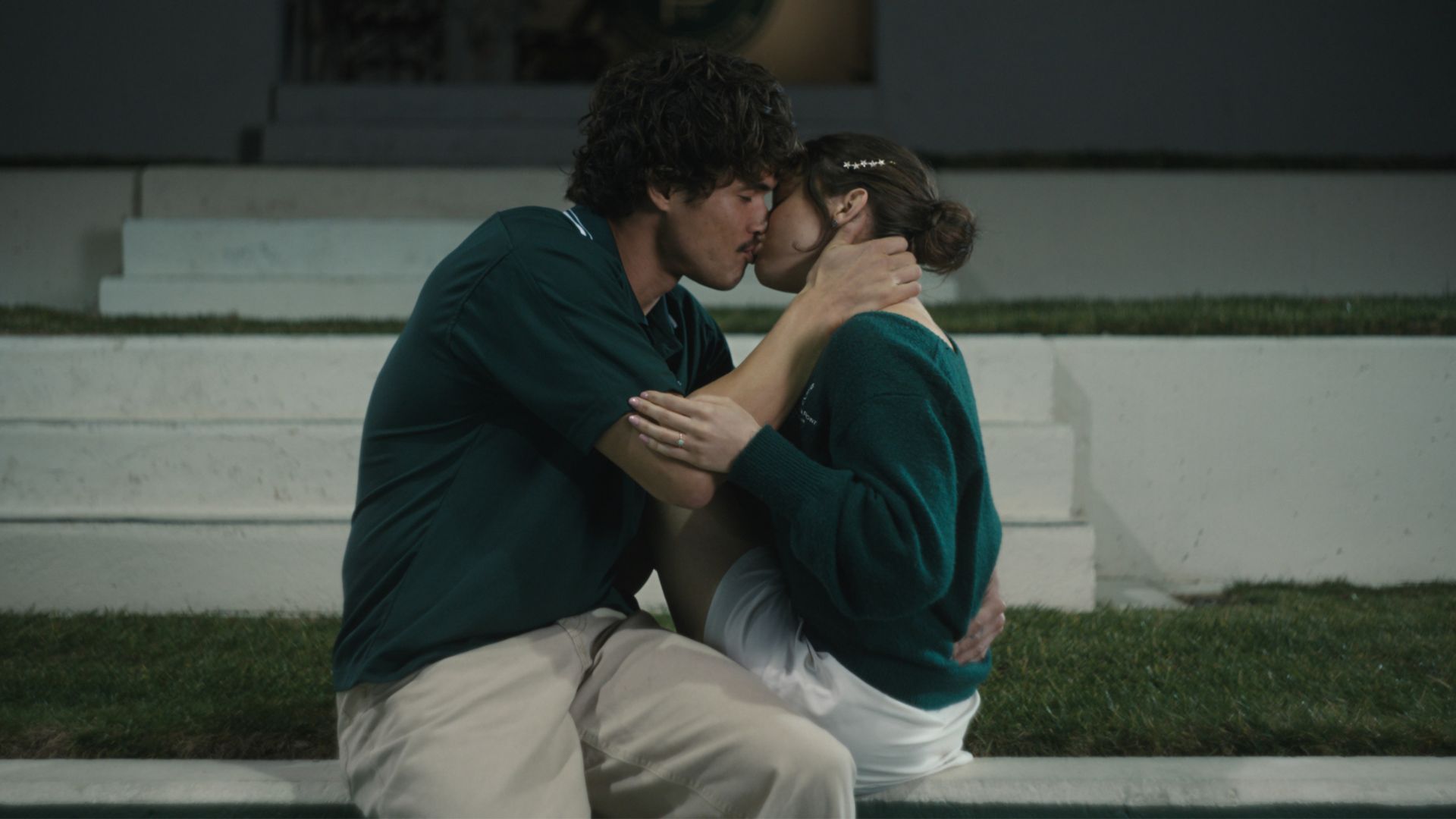 Austin and Ashley kiss on the tennis court steps