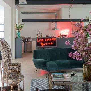 living room with dark green sofa designed chair and flower vase