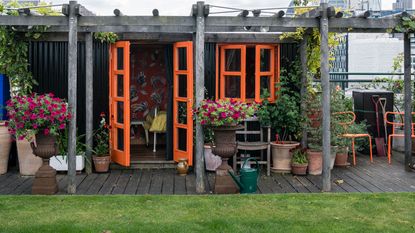 garden with bright orange doors leading onto it