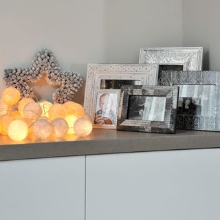 grey wall with light and photo frames