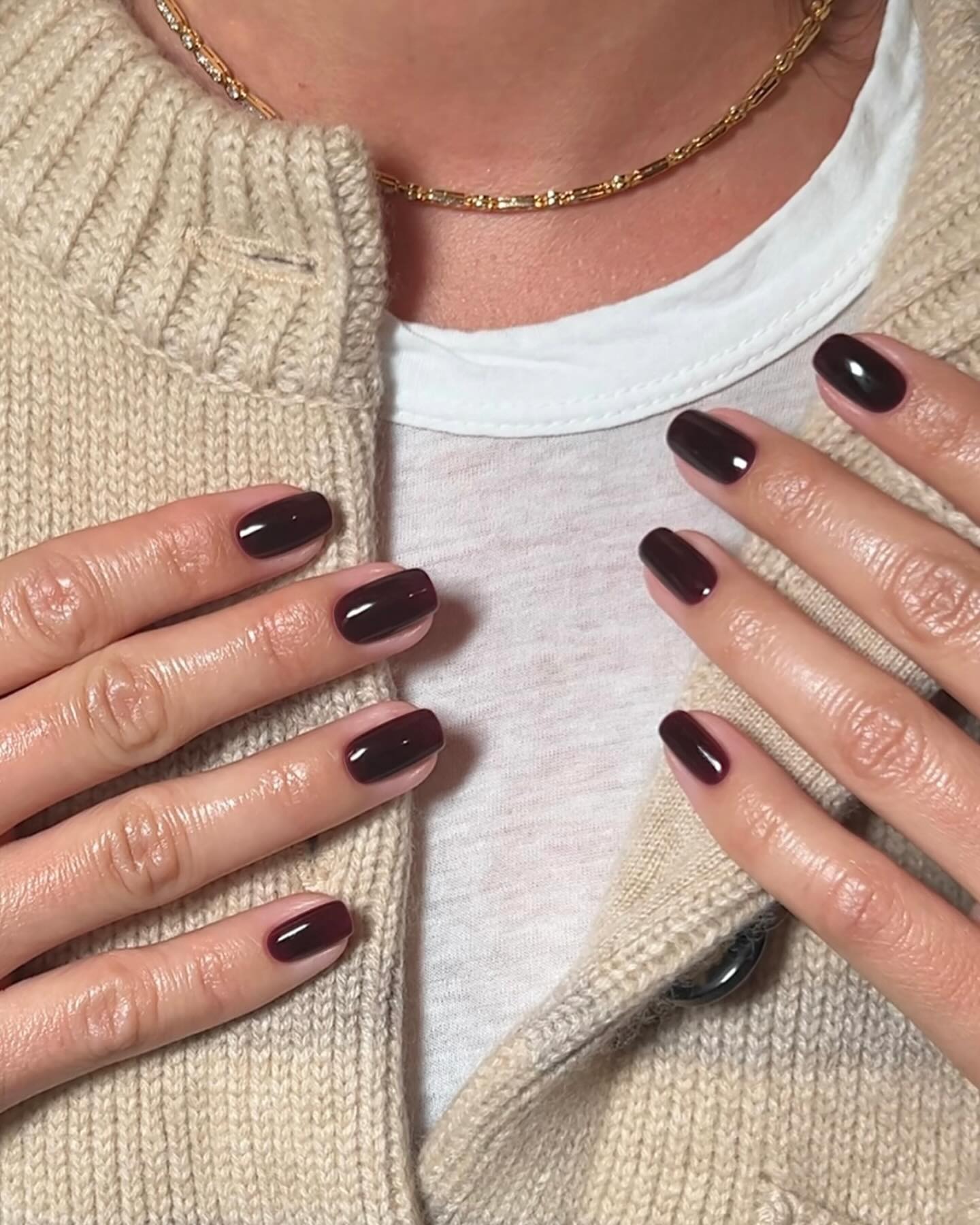 A woman with long, dark burgundy nails
