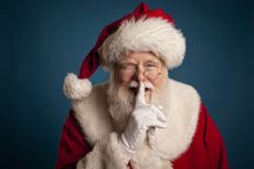 Santa Claus or Father Christmas with his finger on his lips, saying ssh.