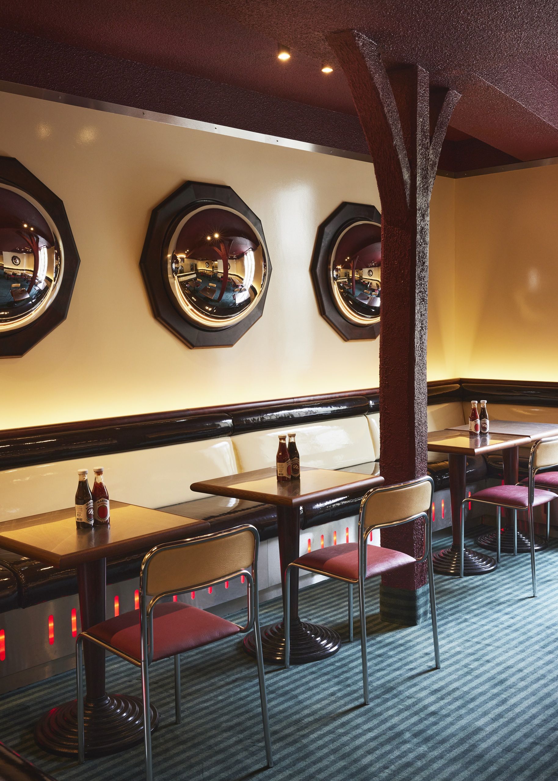 the interiors of a diner in paris with blue and red color palettes and retro style