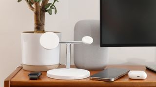 Belkin BoostCharge Pro 3-in-1 Wireless Charger surrounds by Apple products on a wooden desk