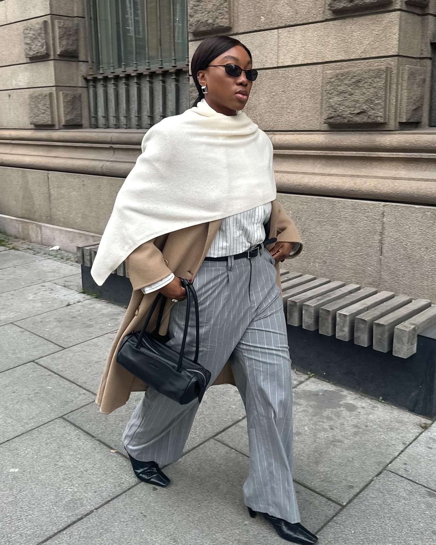 Influencer wears pinstripe trousers.