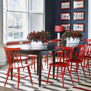 monochrome dining room with grey wall bright red dining chairs