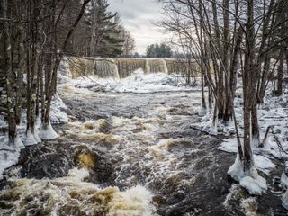 Scenic view of river flowing in forest during winter, Peterborough, New Hampshire.