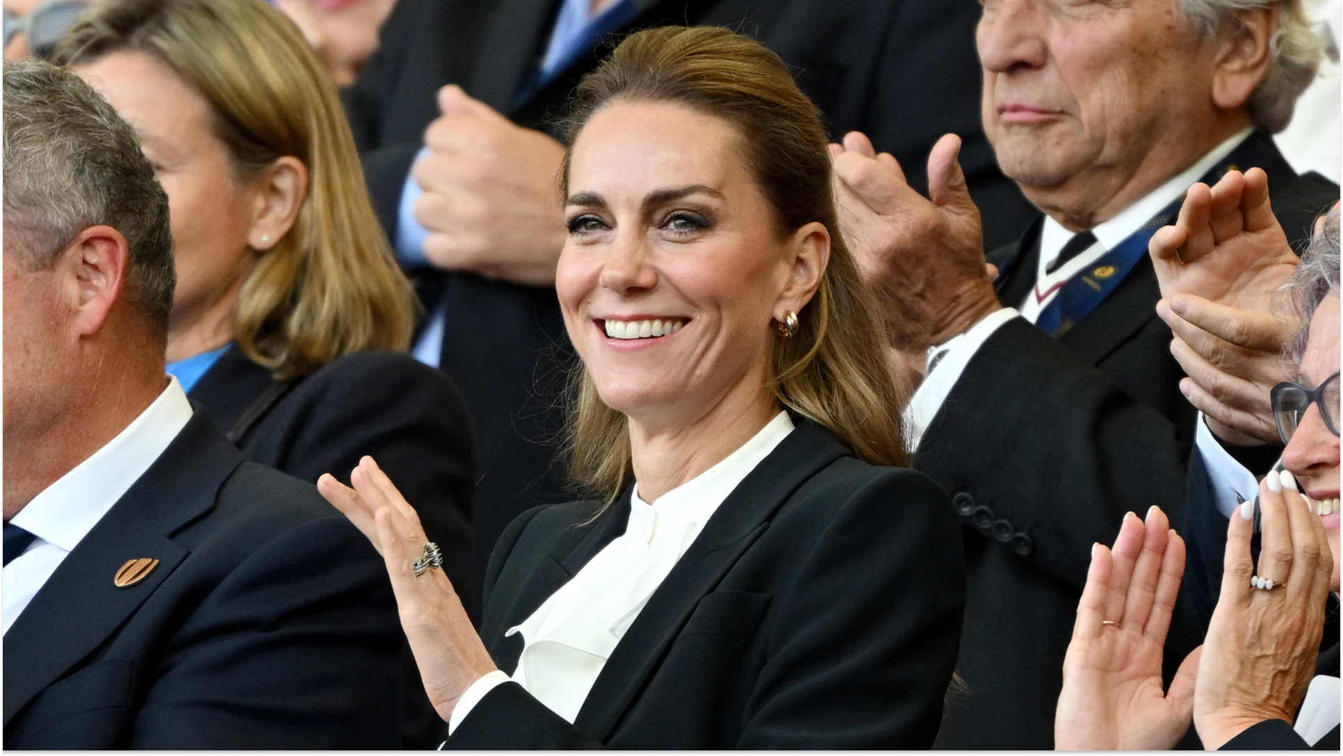 Kate Middleton attends the women's rugby wearing a black suit and ruffled white shirt