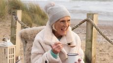 Mary Berry smiles as she eats soup at Camber Sands beach