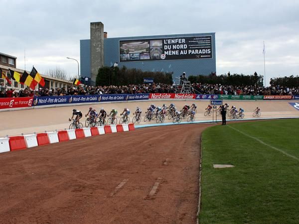 The first big group comes around the banking inside the Roubaix velodrome.