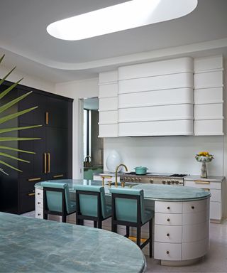 kitchen with white walls and teal coloured bar stools at island