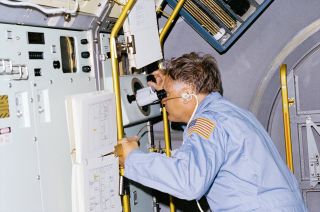 NASA astronaut Don Lind observes crystals being grown on board the Spacelab 3 science module during space shuttle Challenger's STS-51B mission in 1985.
