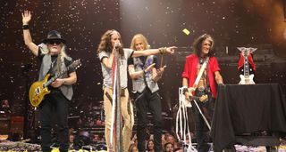 Aerosmith take a bow at the end of one of their final shows on the Peace Out Tour, with Steven Tyler pointing someone out in the crowd and Brad Whitford (far left) with his gold PRS