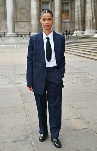 Gugu Mbatha-Raw attends London Fashion Week wearing a suit and black loafers.