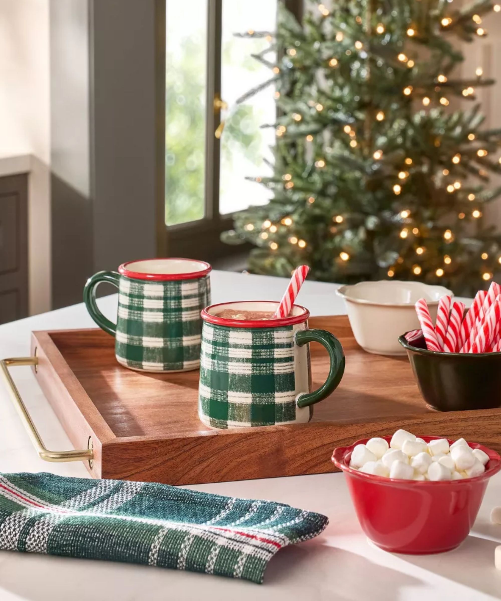 Table with red pinch bowls, plaid napkins and green plaid ceramic mugs
