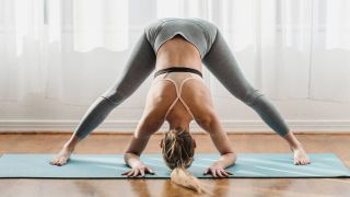 Woman in wide-legged standing forward bend position