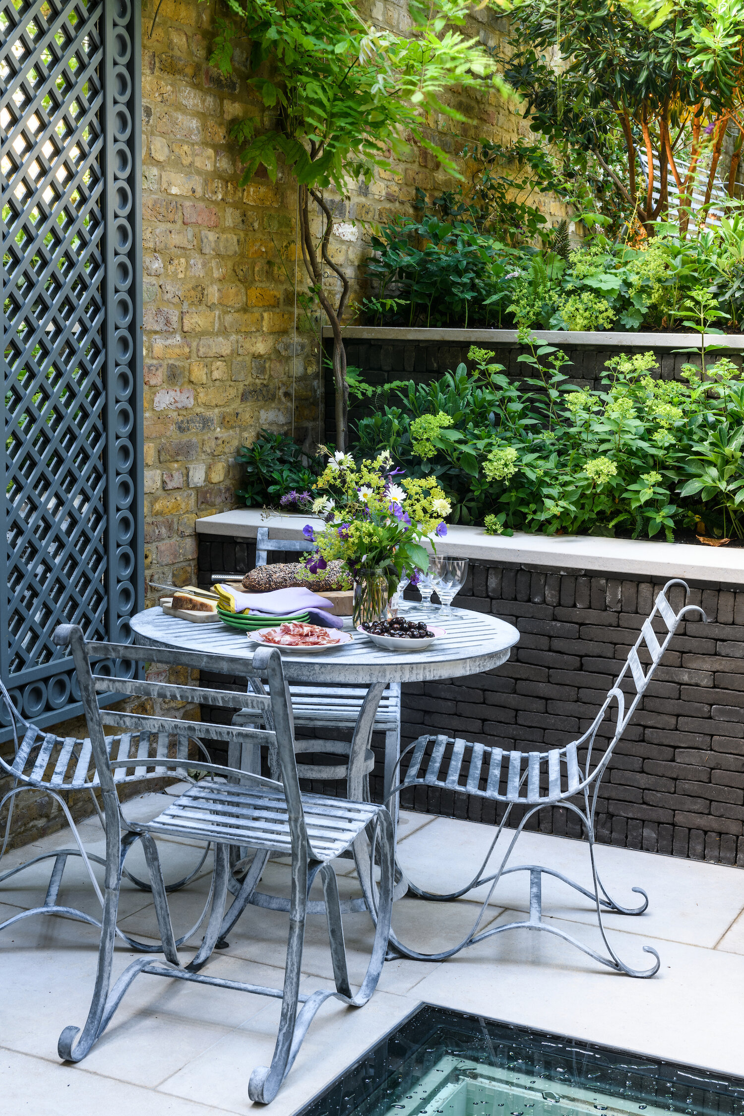 garden mirror in courtyard next to outdoor table