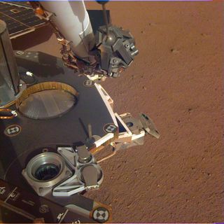 NASA's Mars InSight lander's instrument deck stands out against the reddish Martian soil in this photograph, sent to Earth on Dec. 4, 2018.