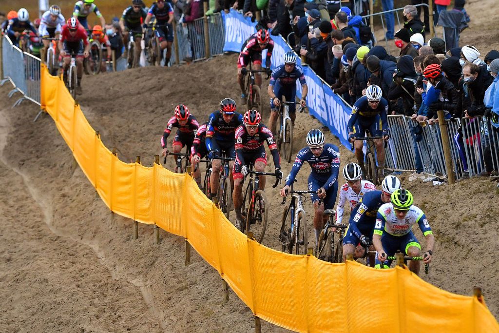 KOKSIJDE BELGIUM NOVEMBER 21 A general view of Toon Aerts of Belgium and Team Baloise Trek Lions Laurens Sweeck of Belgium and Team Pauwels Sauzen Bingoal David Van Der Poel of Netherlands and Team AlpecinFenix Eli Iserbyt of Belgium and Team Pauwels Sauzen Bingoal Vincent Baestaens of Belgium and Team DeschachtGroup HensContainers Maes and riders compete while fans cheer during the 50th Koksijde UCI CycloCross Worldcup 2021 Mens Elite CXWorldCup on November 21 2021 in Koksijde Belgium Photo by Luc ClaessenGetty Images