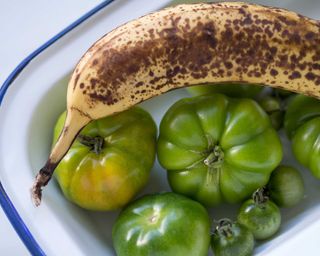 green tomatoes in bowl with banana
