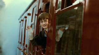 Daniel Radcliffe as Harry Potter waving while on the Hogwarts Express at the end of Harry Potter and the Sorceror's Stone 