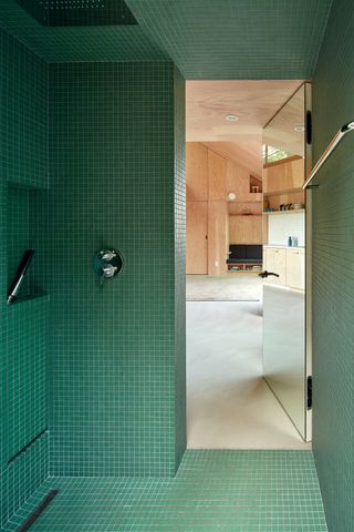 green mosaic-tiled bathroom, looking out to cabin interior