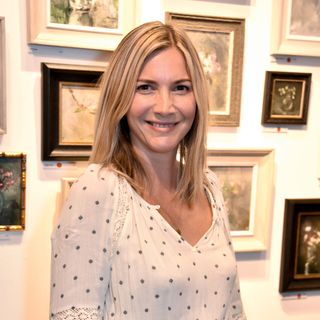 Lisa Faulkner wearing a white pokla dot dress standing in front of a gallery wall
