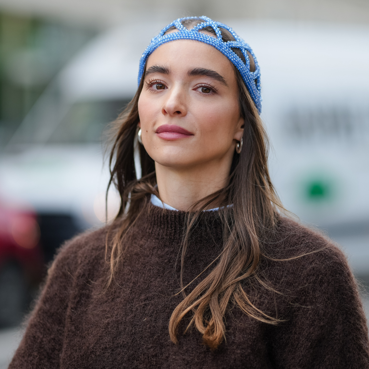 Permanent make-up A guest wears a blue patterned pearls headband hat and has long, loose hair. The outfit includes a dark brown, textured sweater layered over a light blue collared shirt with visible cuffs, outside Munthe, during Copenhagen Fashion Week, on August 06, 2025 