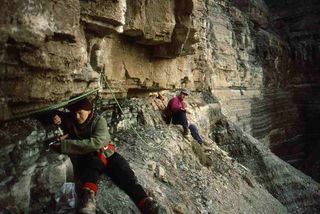 Mark Sephton (right) and Cindy Looy (left) take samples of rocks that date to the end of the Permian period from high in the Butterloch Gorge, in Italy.