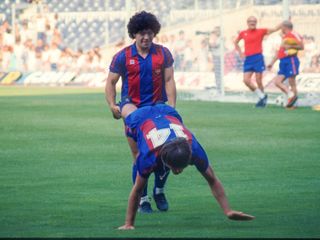 The Argentinian football star Diego Armando Maradona holds the legs of his teammate Migueli, in an exercise during training with F.C. Barcelona, held at Camp Nou, Barcelona, Spain, on July 28, 1982.