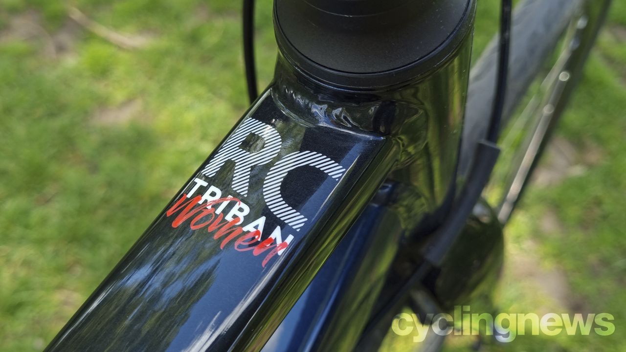 A close up of the Triban's top tube where there's a white and red logo that says Triban Women