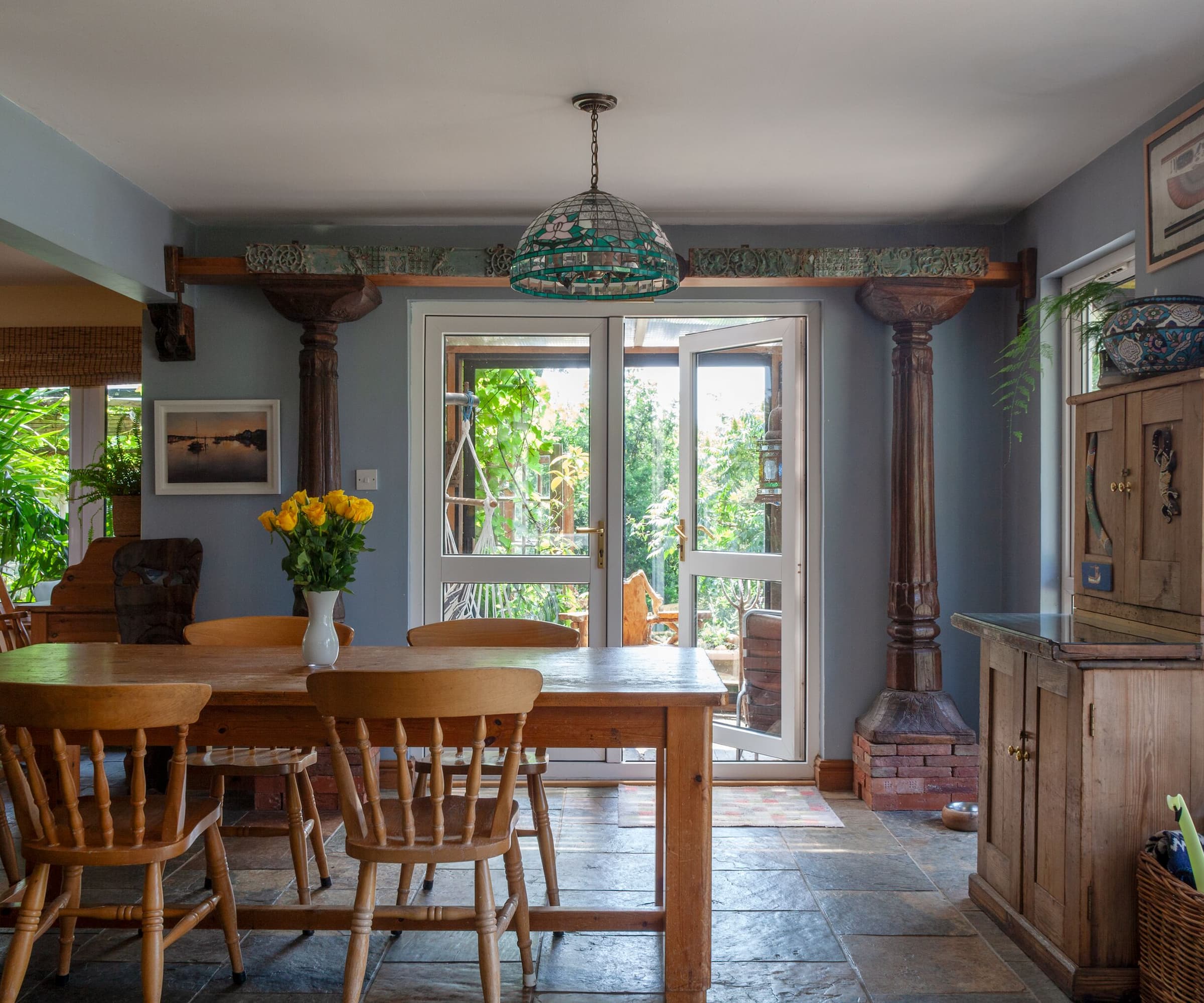 A kitchen-dining area with porcelain floors and a wooden table