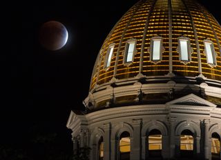 Supermoon lunar eclipse over domed building