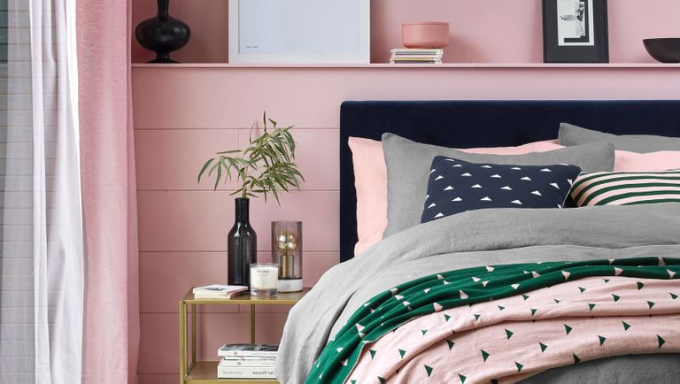 Decorating with blush pink pink bedroom with pink walls, grey bedding and a grey bedside table 