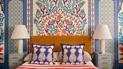 Bedroom with blue patterned statement wall behind the bedhead