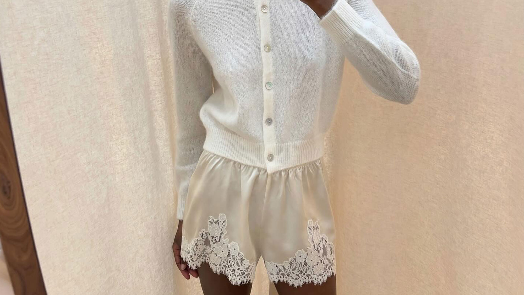 French woman in lace shorts and white cardigan.