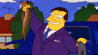 Mayor Quimby smiling and holding up a handful of dead snakes