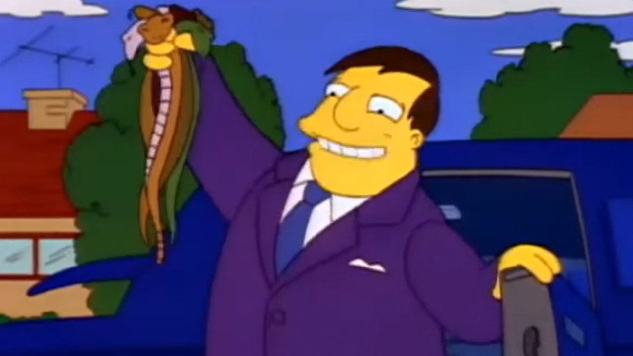 Mayor Quimby smiling and holding up a handful of dead snakes