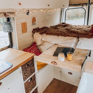 van makeover with bed and slideout table and sink and kitchen unit