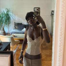 A woman taking a selfie in a Parisian apartment with a mullet bob hairstyle