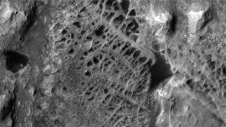 a greyscale landscape seen from high above, with overlapping twisting paths.