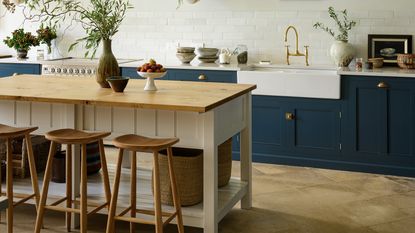 deVOL kitchen with navy shaker cupboards and prep table in the centre.