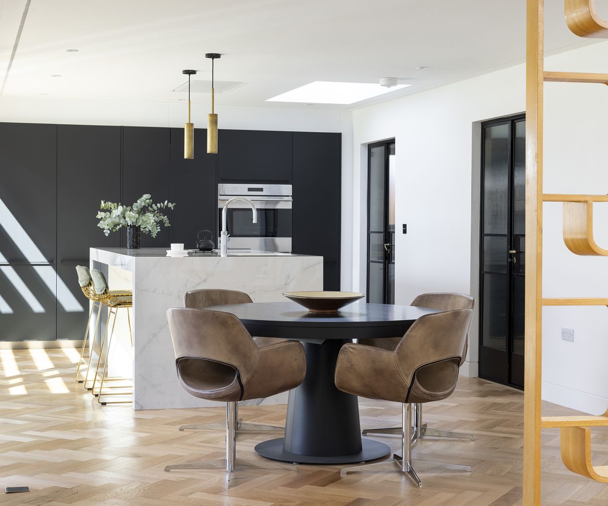 View of an open plan kitchen diner with circular table and chairs