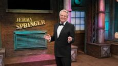 Jerry Springer stands on the set of his show