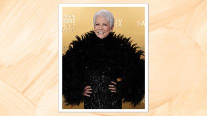 Jamie Lee Curtis at the SAG Awards 2025, smiling with a silver pixie cut and wearing a feathered, glittery black gown, on a tan background