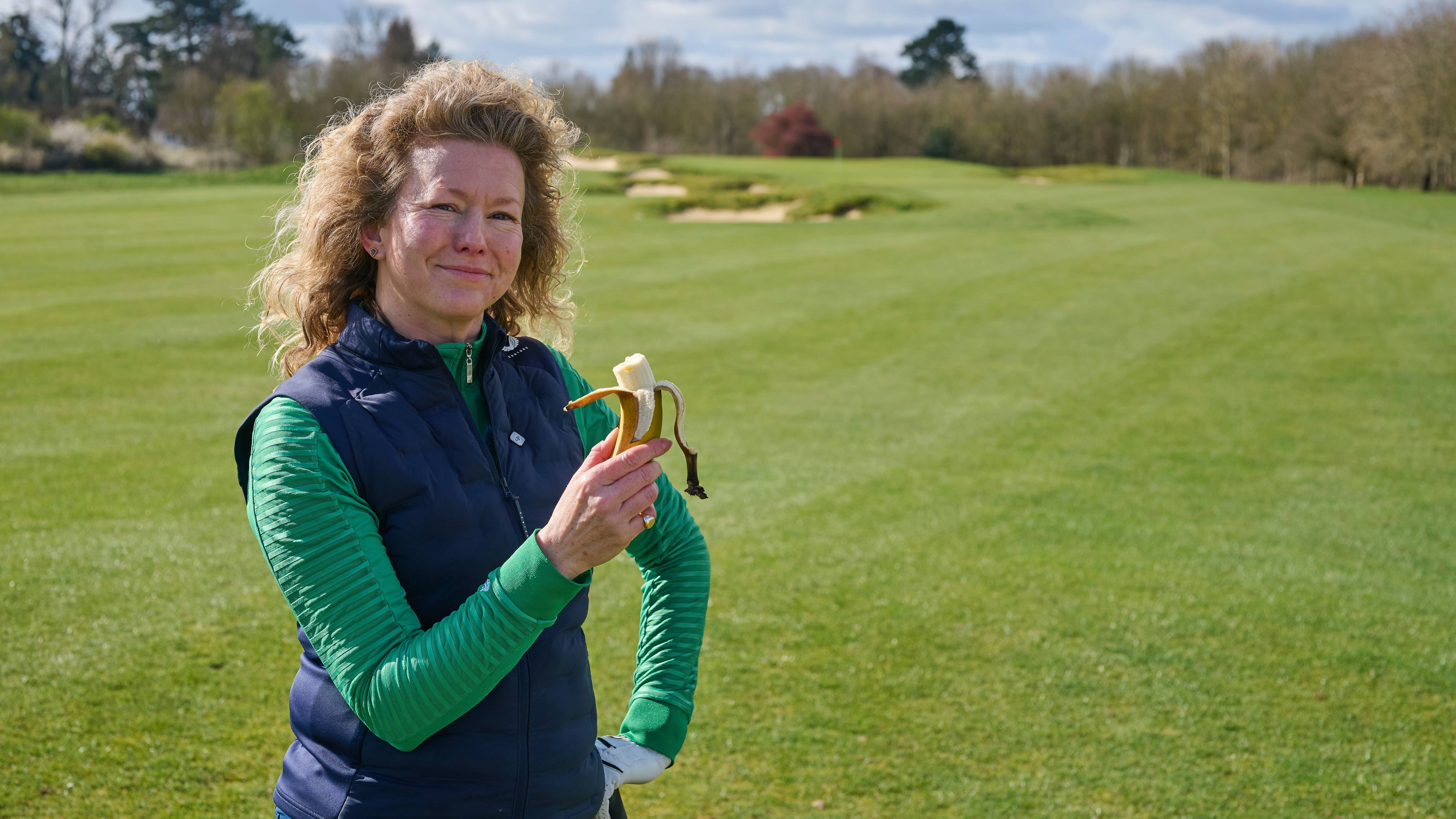 Katie Dawkins eating a banana to re-fuel on the golf course