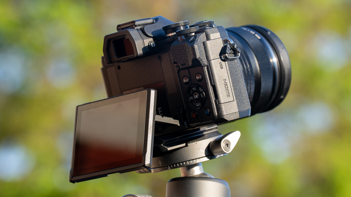 Olympus OM-D E-M10 Mark IV on a tripod with the screen flipped down.