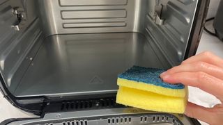 Sponge being used to clean the Tower Air Fryer Oven