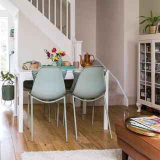 A dining area within a living room with a white extendable dining table